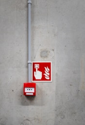 A red and white fire extinguisher sign on a concrete wall