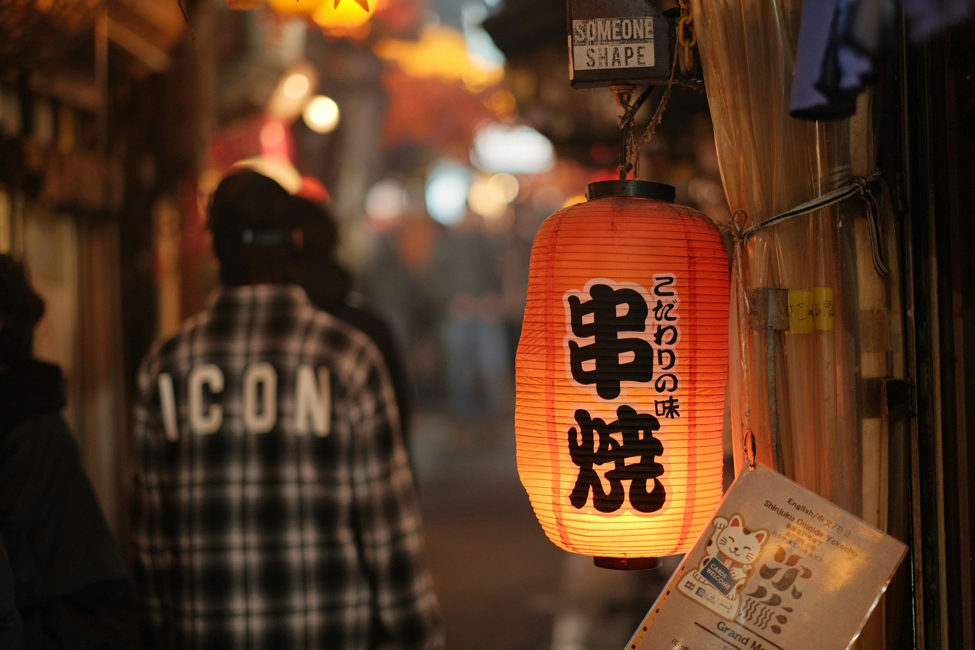 A couple of people walking down a street at night