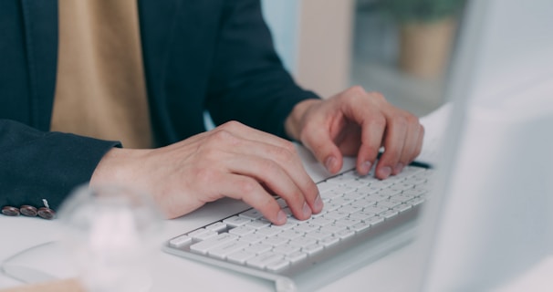 A person typing on a keyboard at a desk