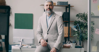A man sitting on a desk in an office