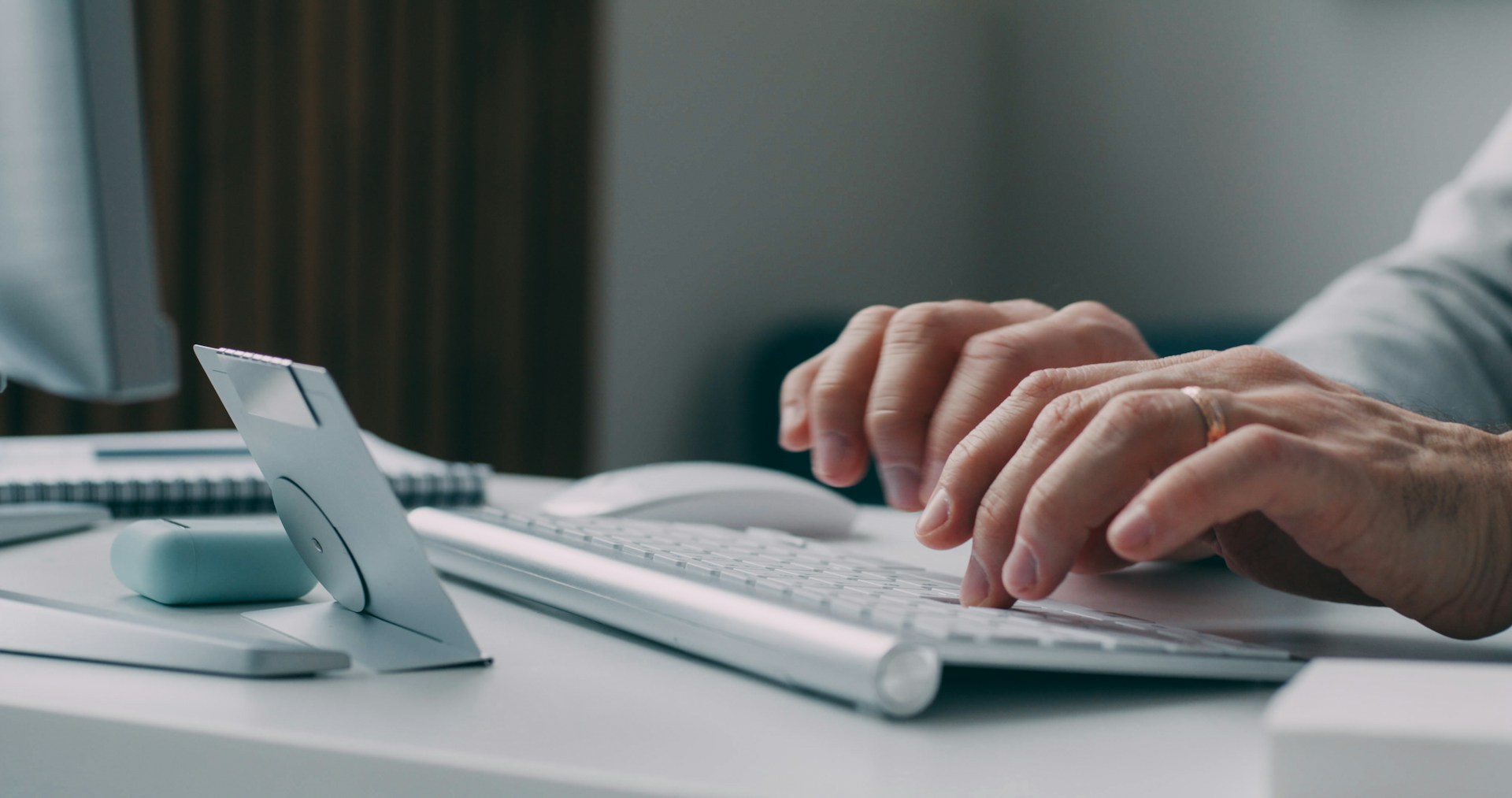 A person typing on a keyboard at a desk