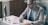 A man sitting at a desk writing on a piece of paper