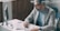 A man sitting at a desk writing on a piece of paper