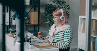 A woman sitting at a desk with headphones on