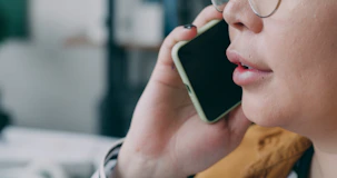 A woman with glasses talking on a cell phone