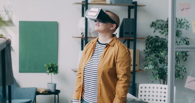 A woman standing in a living room wearing a virtual reality headset