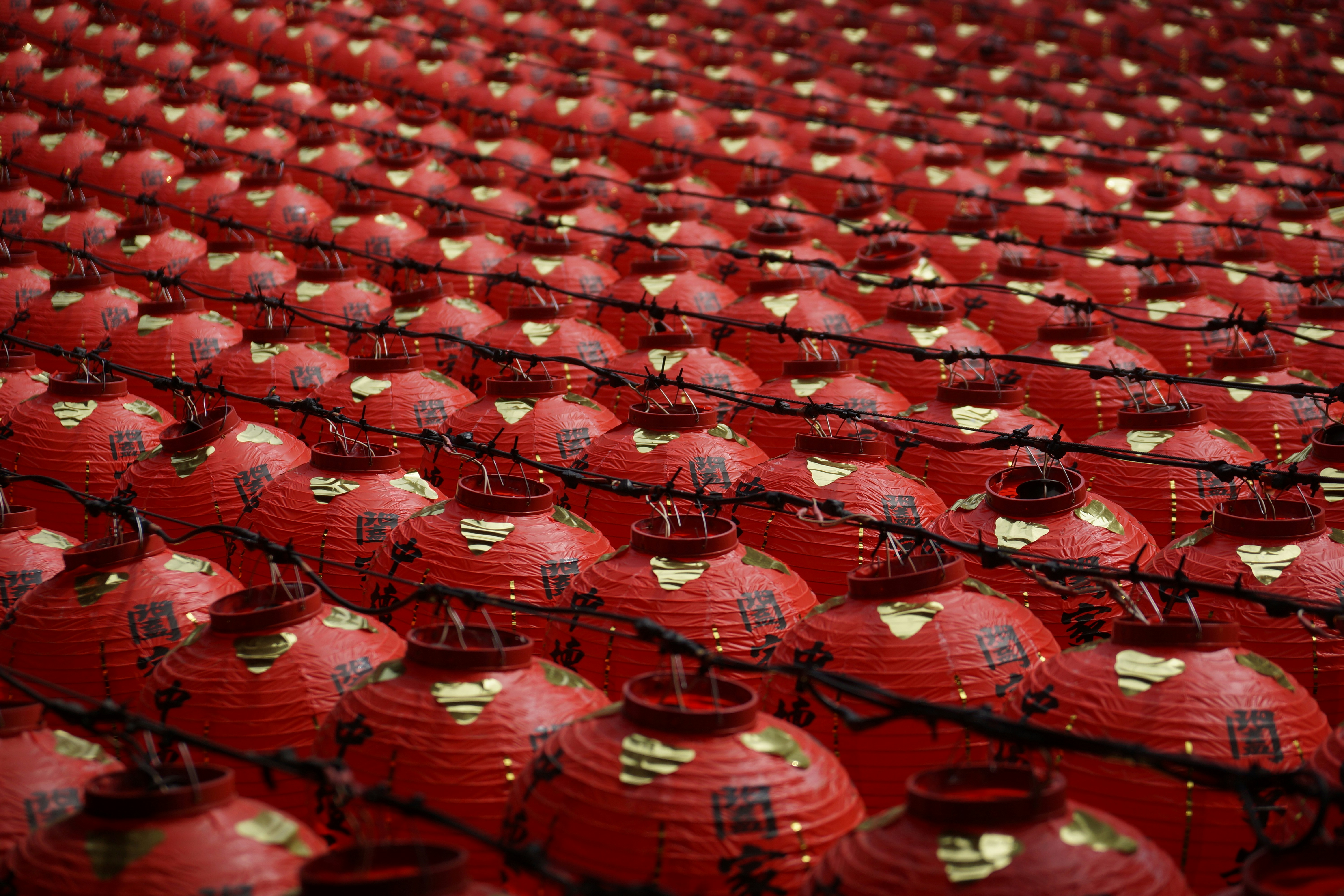 A large group of red vases sitting on top of each other
