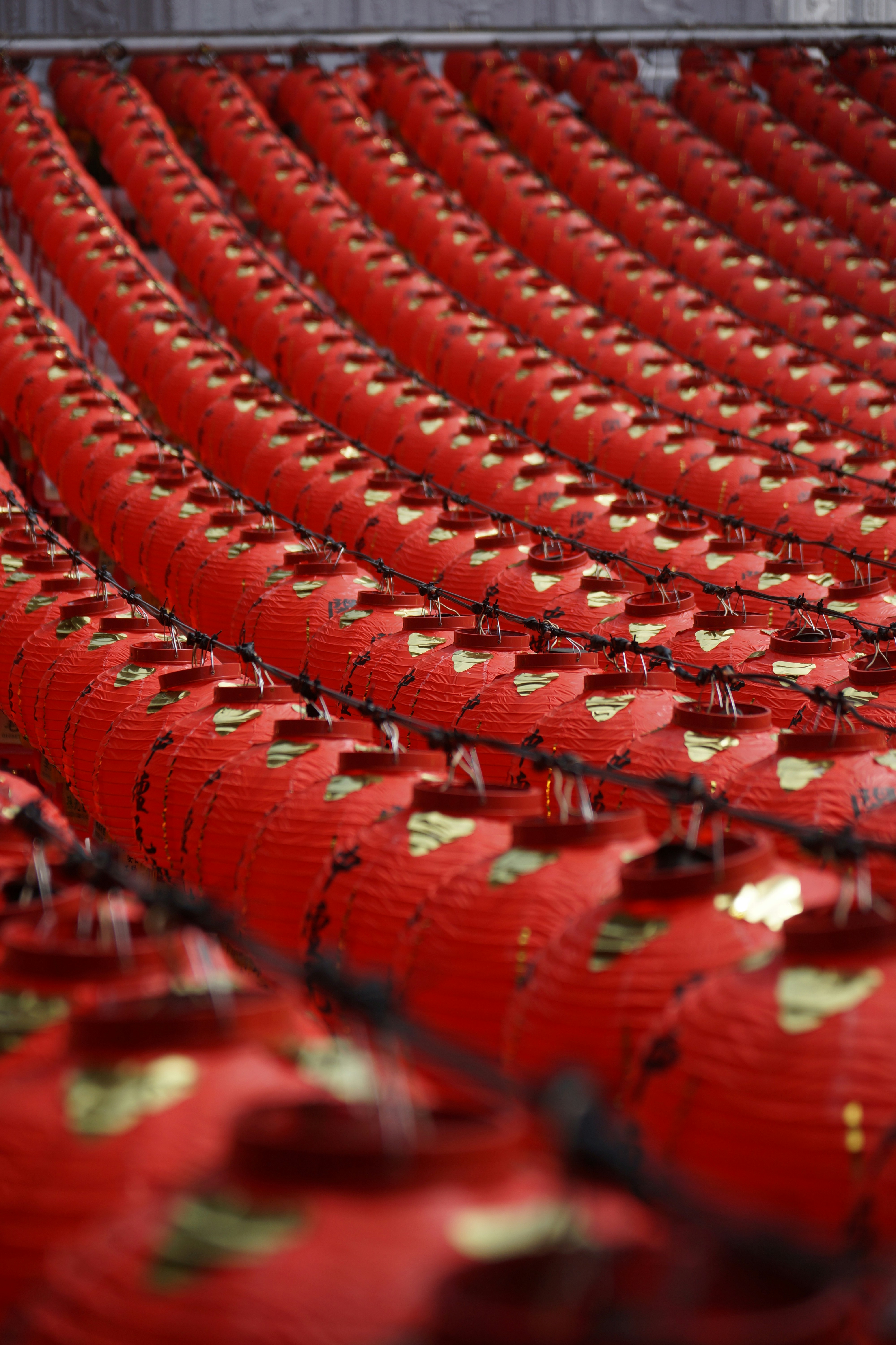 Rows of red vases with gold designs on them