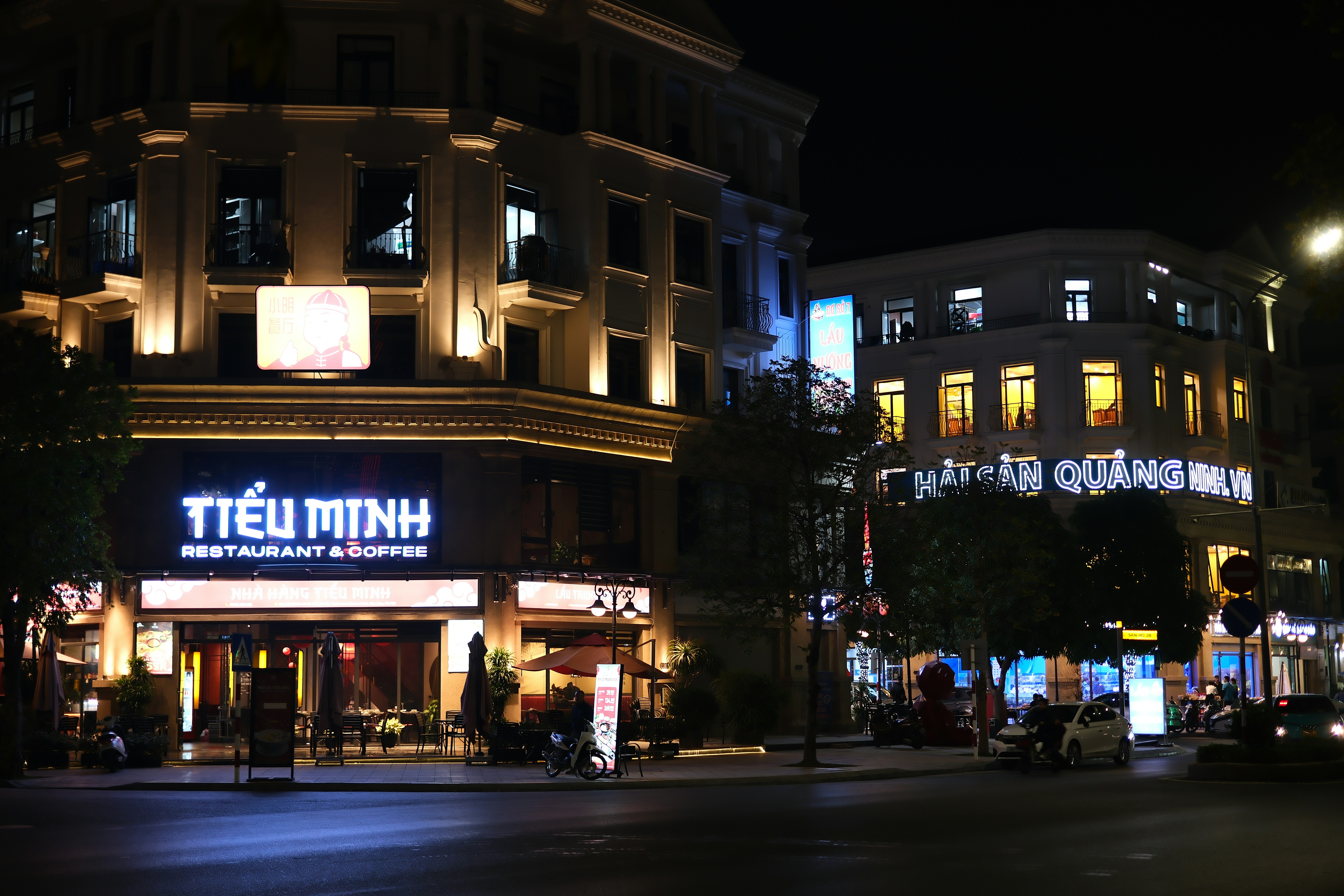A city street at night with buildings lit up