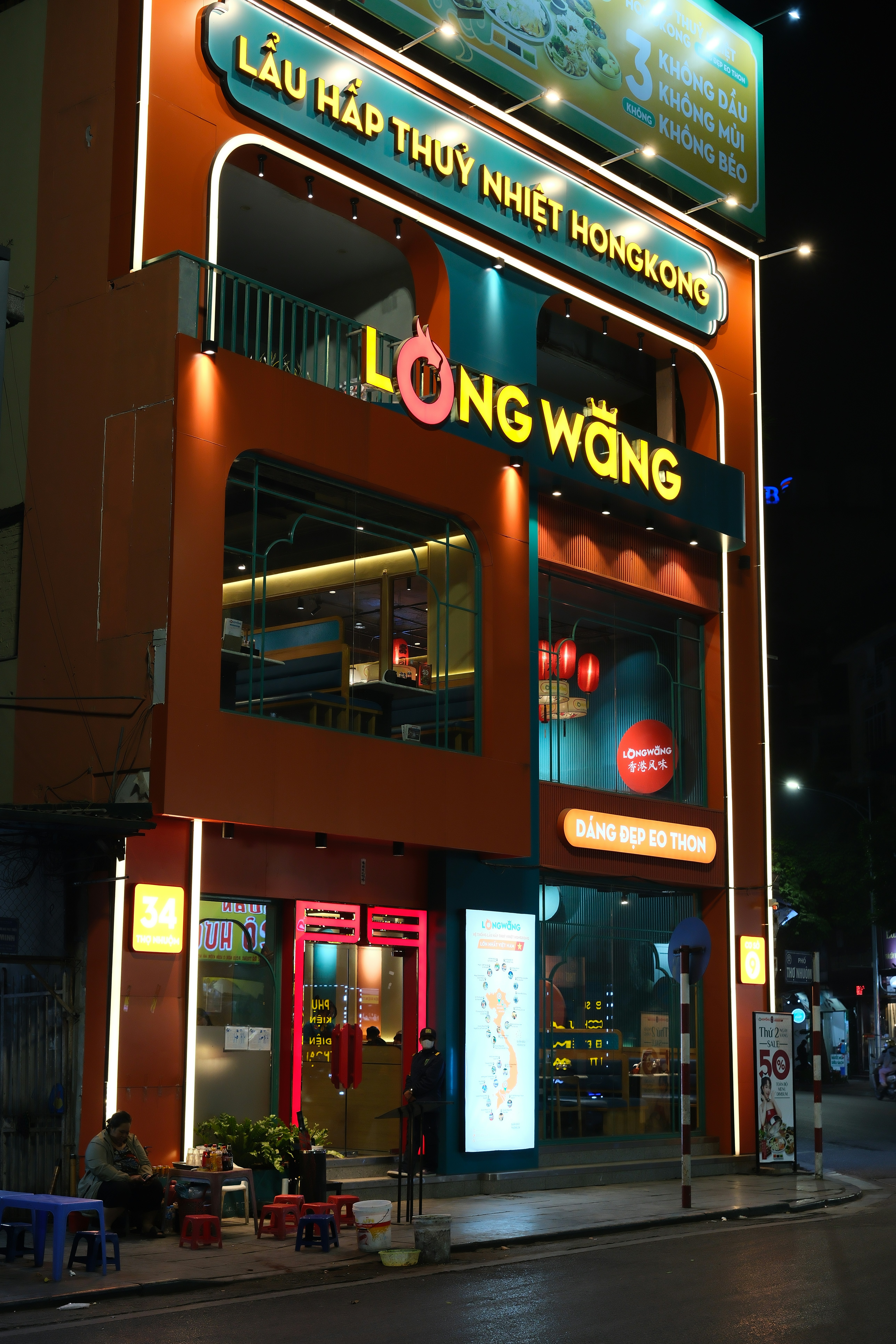 A tall building with a neon sign on top of it