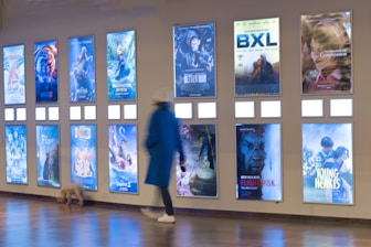 A person walking past a wall with posters on it