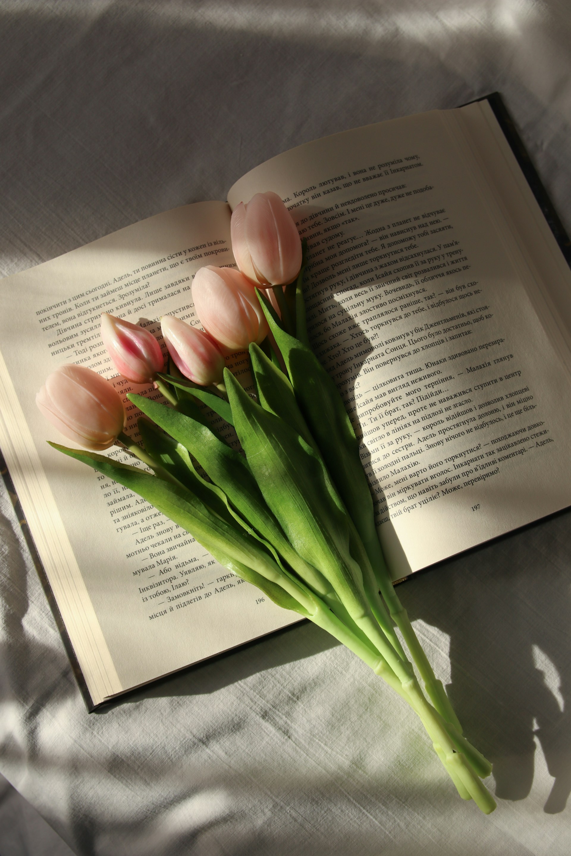 A bouquet of tulips sitting on top of an open book