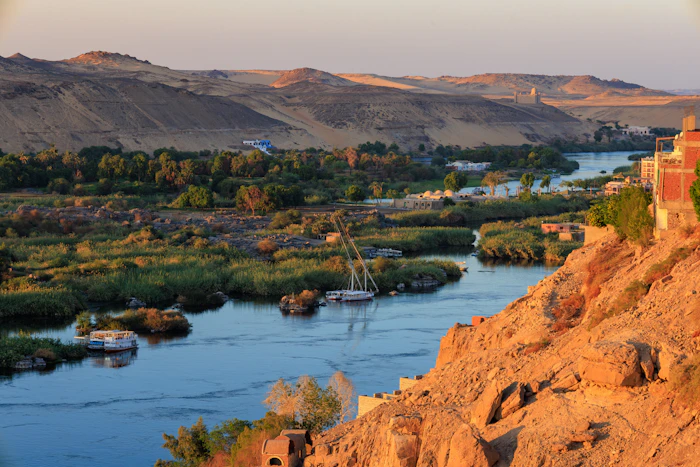 El río Nilo entre palmeras y montañas del desierto en Asuán