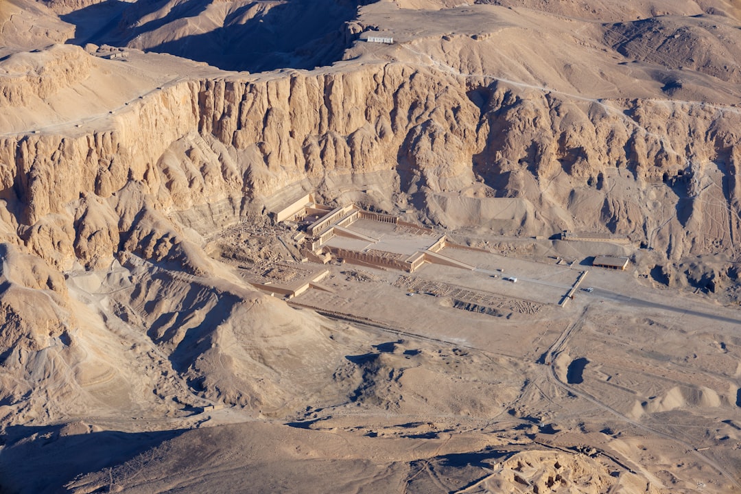 An aerial view of a desert with mountains in the background,
