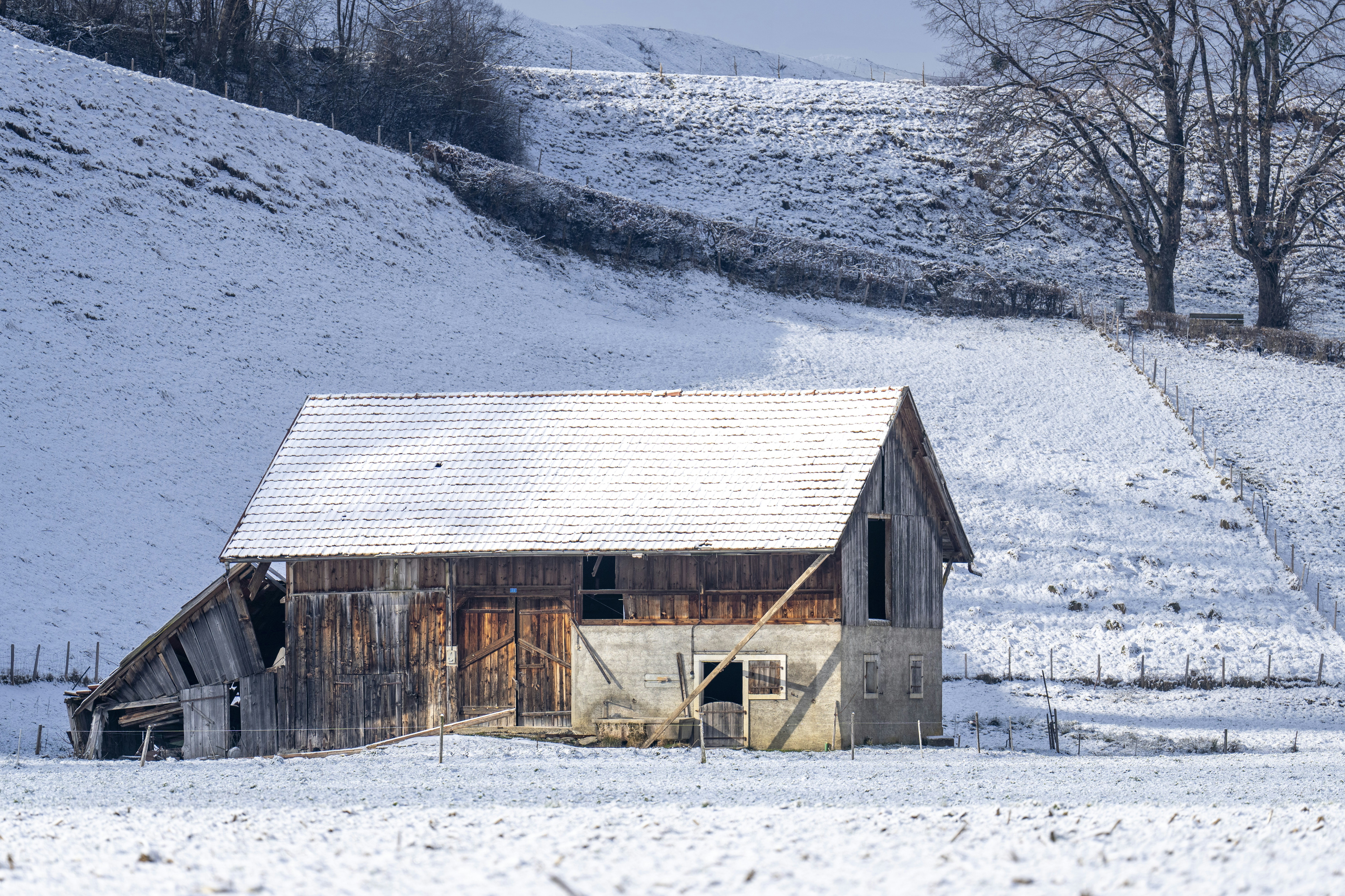 A barn in the middle of a snowy field