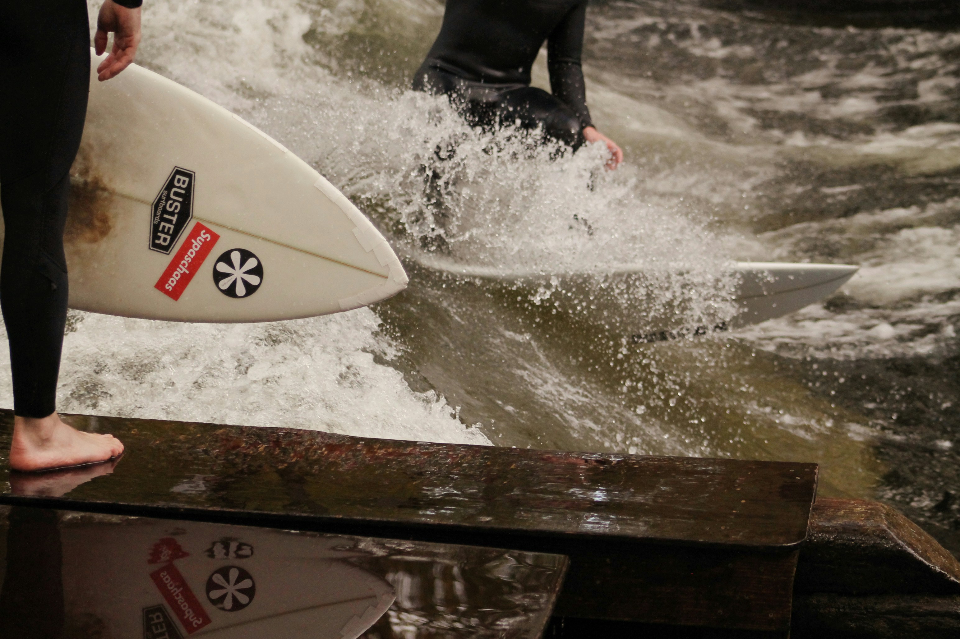 A man in a wet suit holding a surfboard