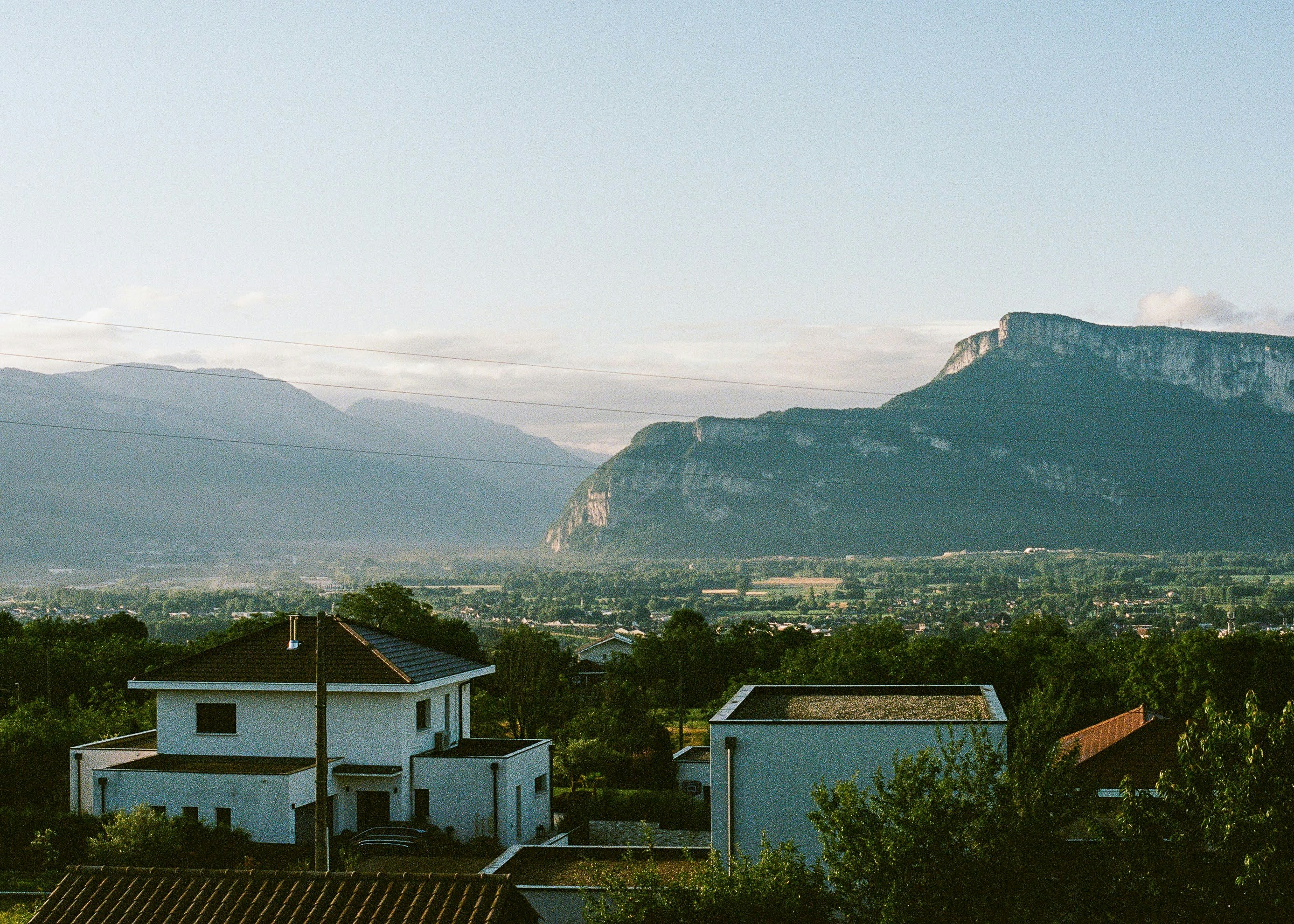 A view of a mountain range with houses in the foreground