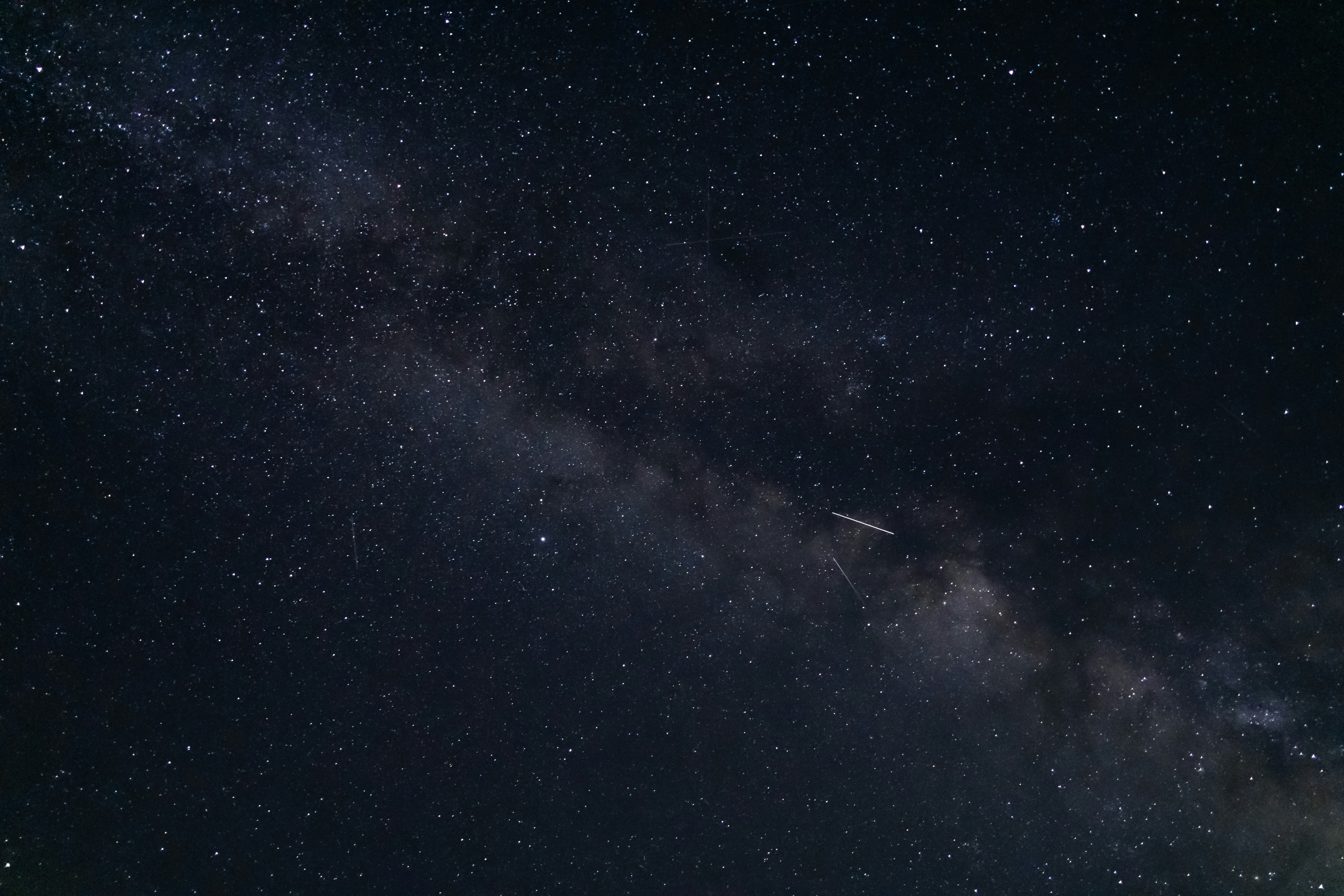 The night sky with stars and a plane in the foreground