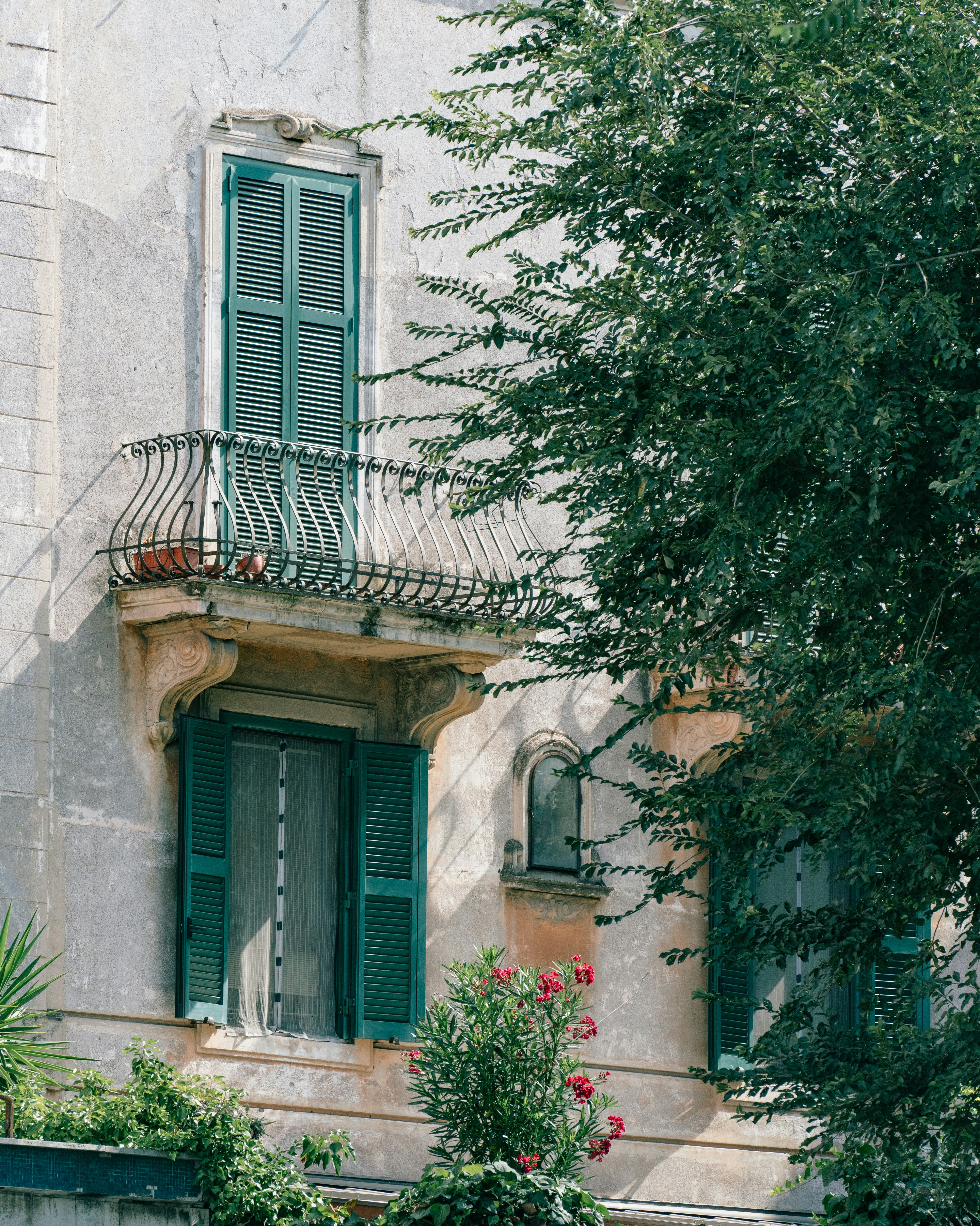 A building with green shutters and a balcony