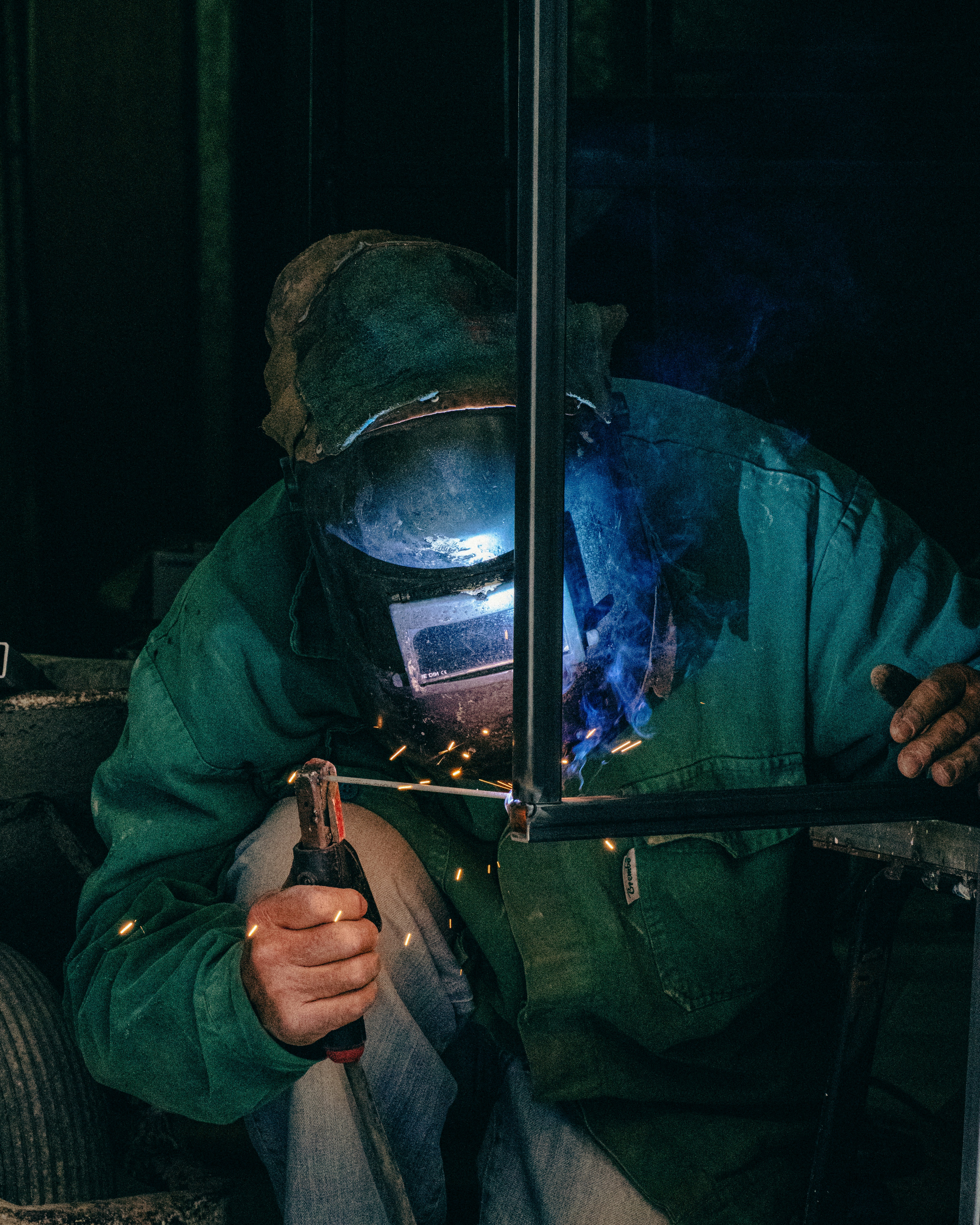 A man in a gas mask welding a piece of metal