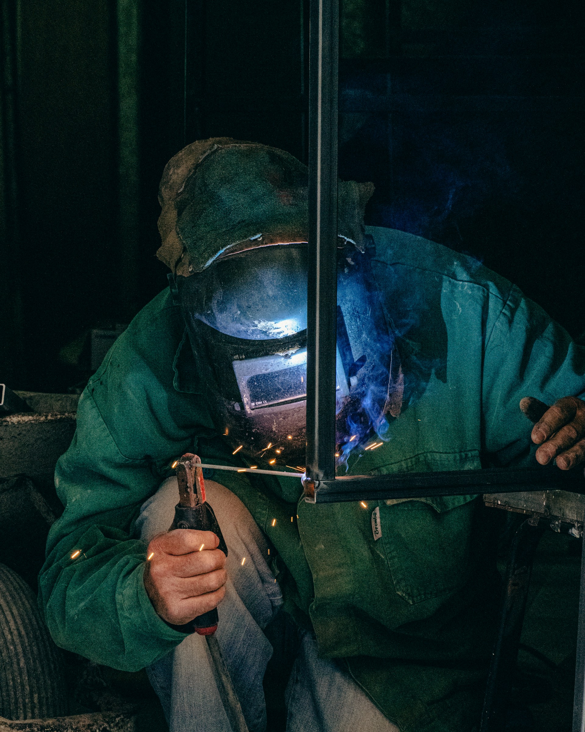 A man in a gas mask welding a piece of metal