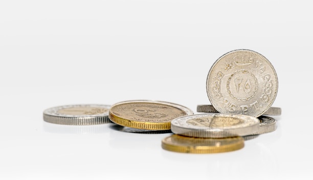 A pile of coins sitting on top of a white table