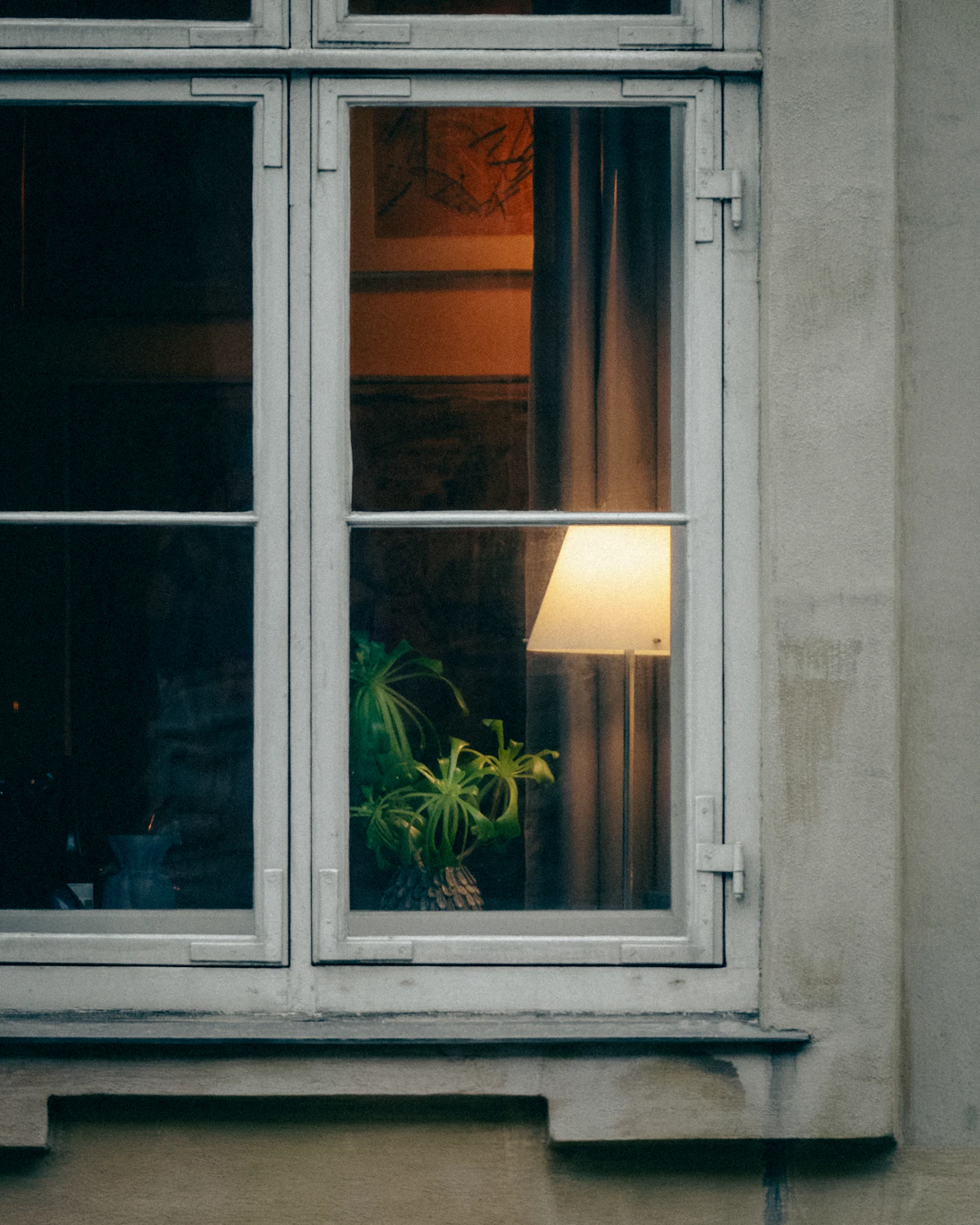 Warm beleuchtetes Fenster am Abend als Symbol für ein neues rauchfreies Abendritual