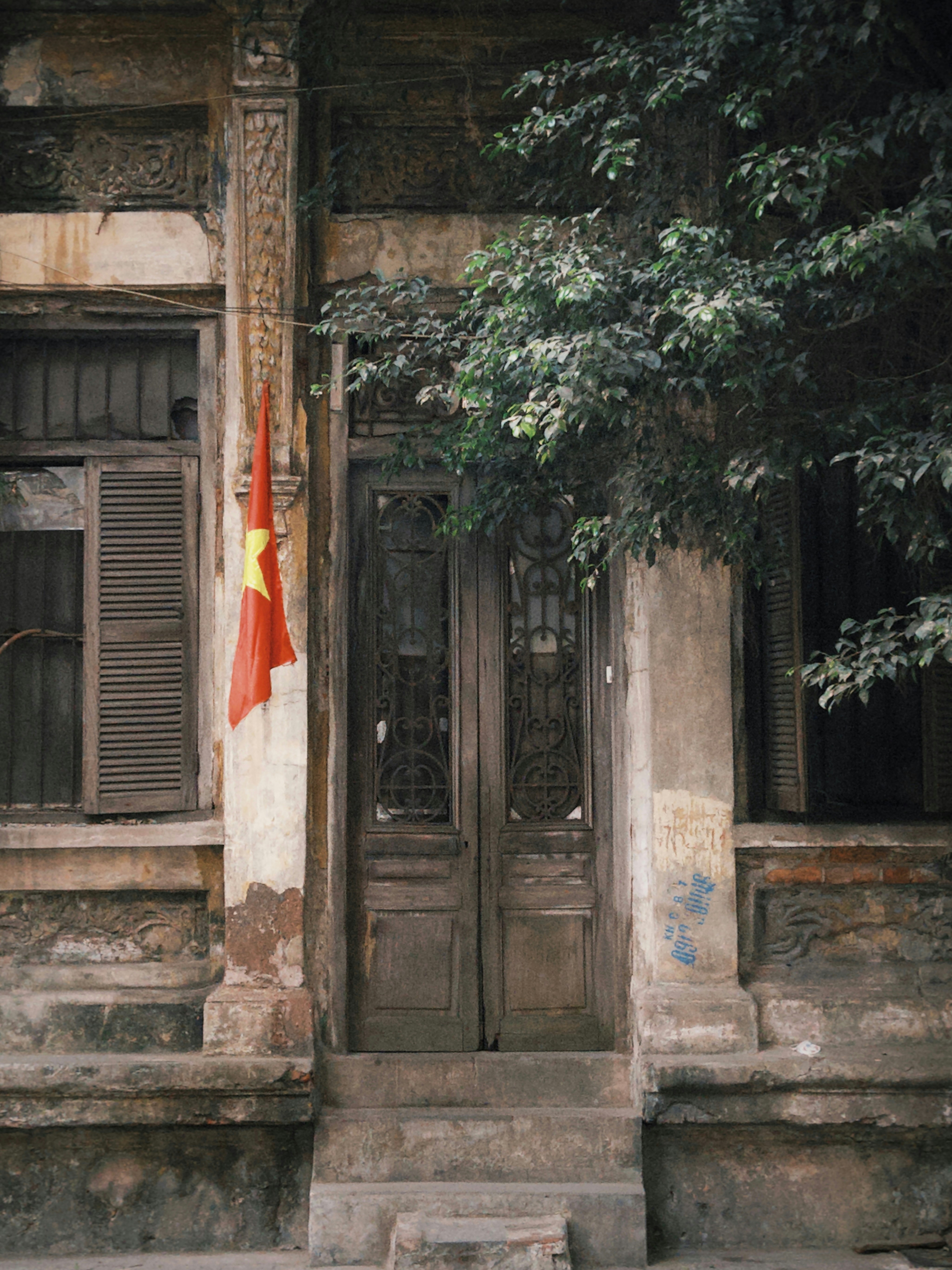 An old building with a red and yellow flag in front of it