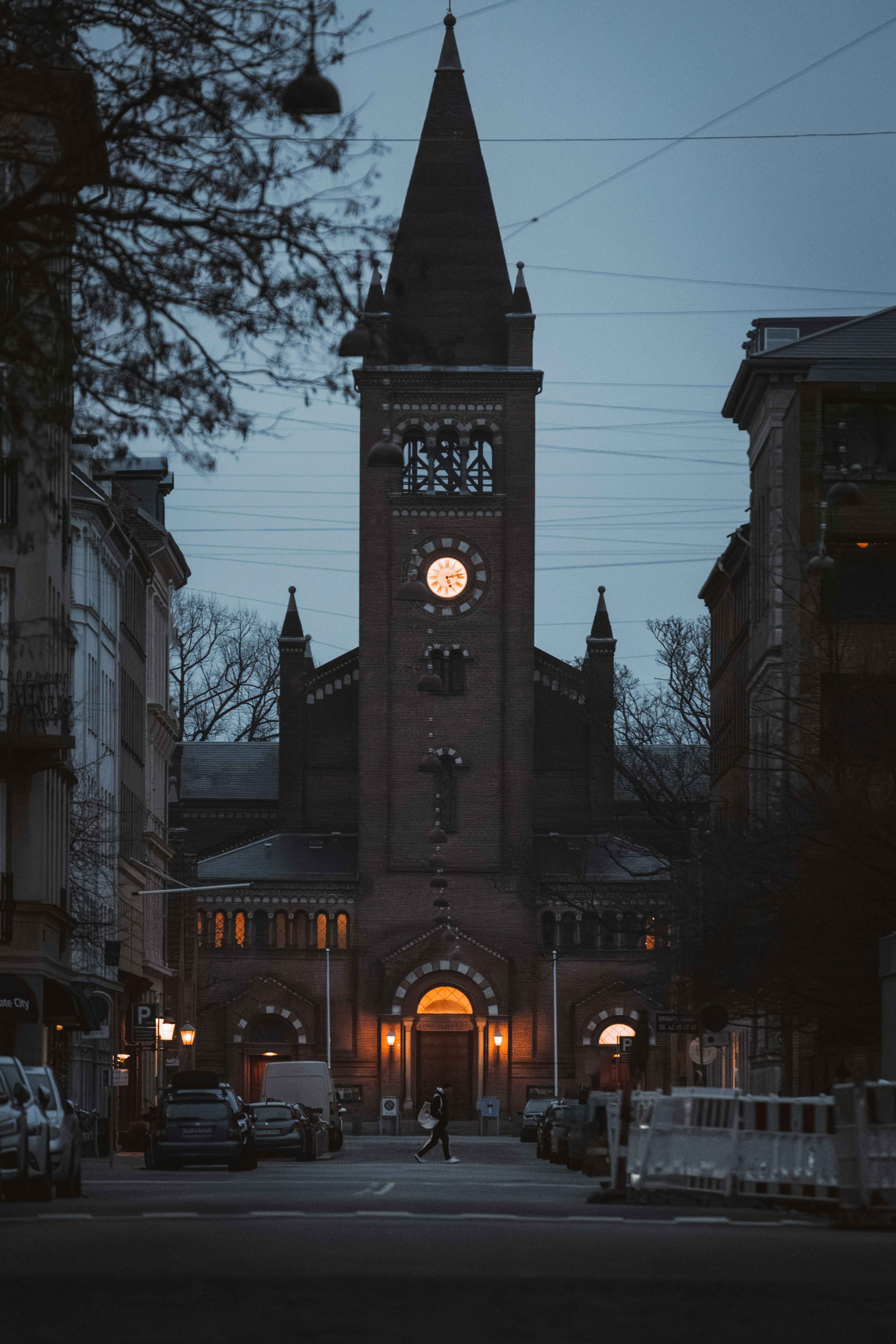 Una iglesia con una torre del reloj iluminada por la noche