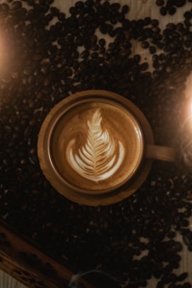 A cup of coffee with a leaf on top of it