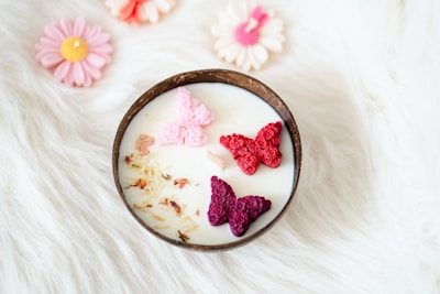 A bowl filled with milk and crocheted butterflies