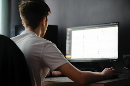 A man sitting in front of a computer monitor
