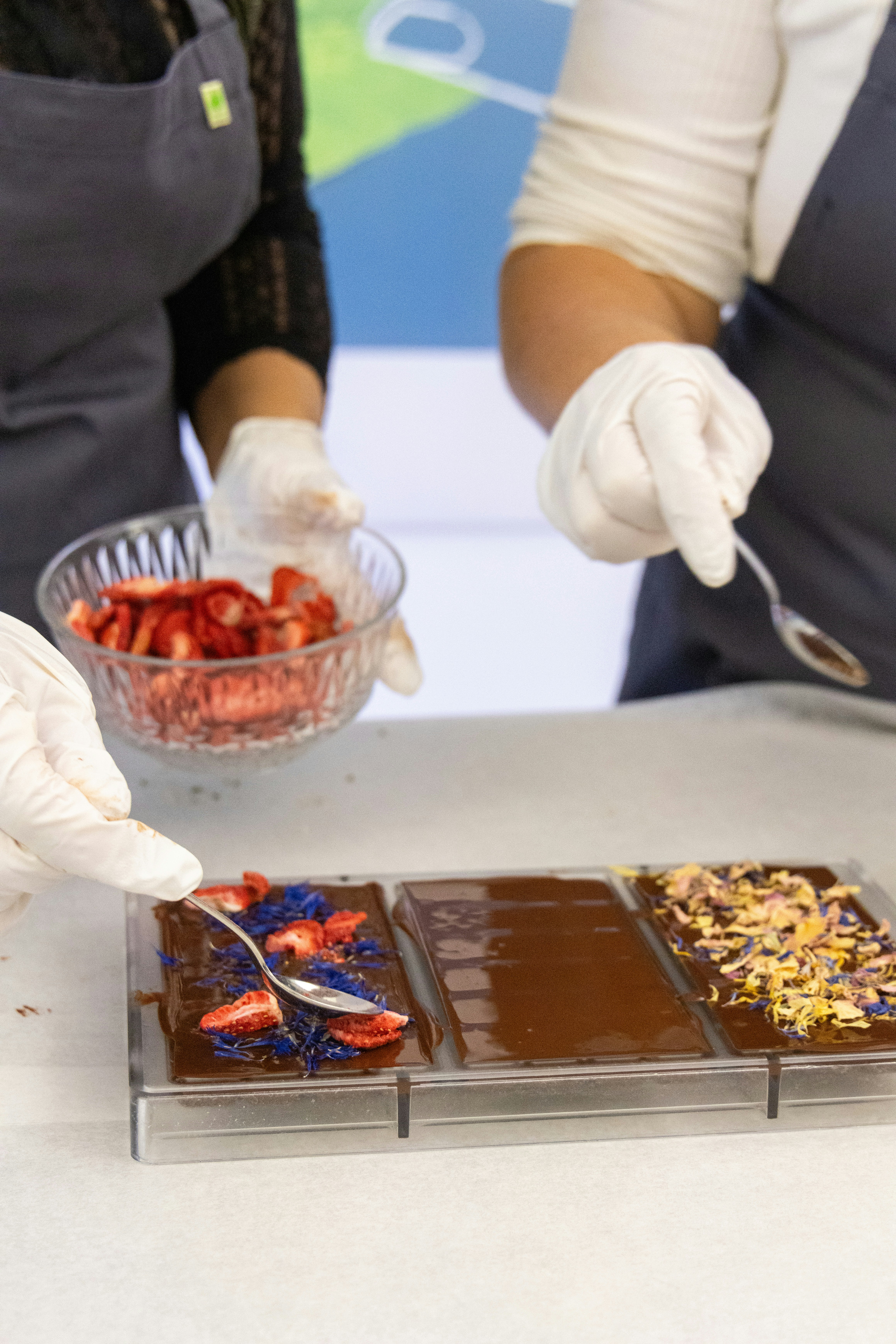 A couple of people that are standing over a table