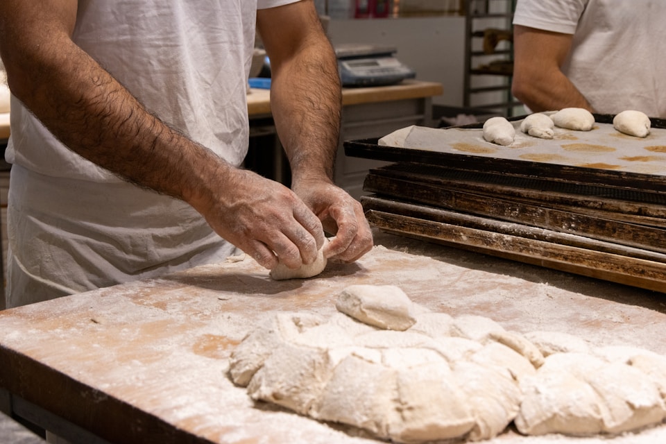A couple of men working in a kitchen preparing food