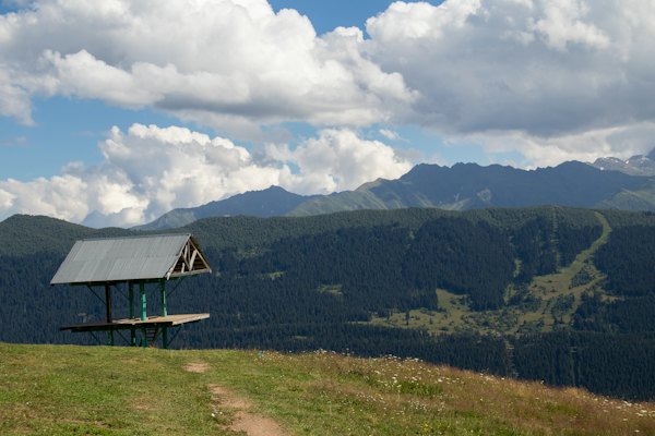 A small cabin sitting on top of a lush green hillside — Mestia, Georgia