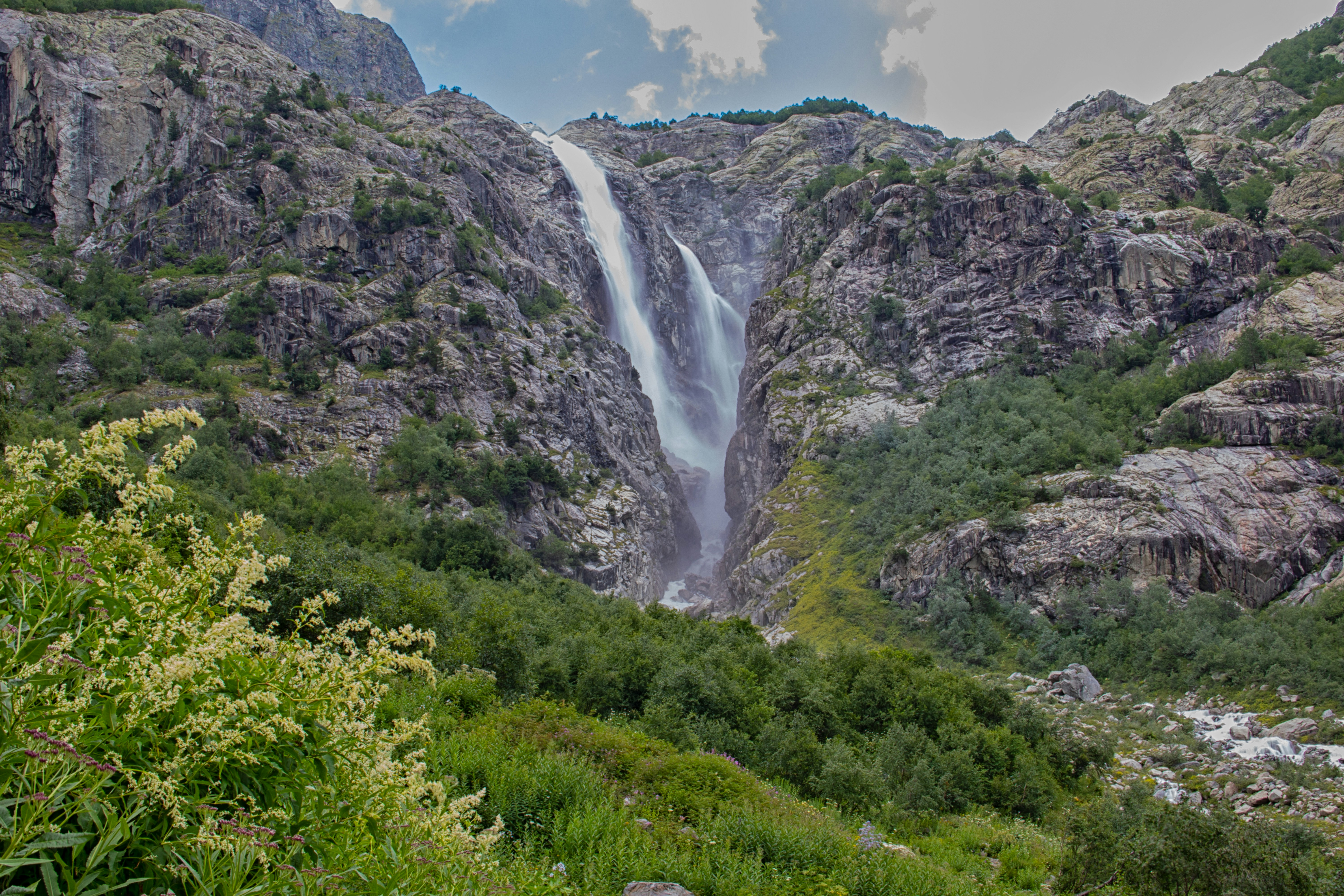 A waterfall in the middle of a lush green valley