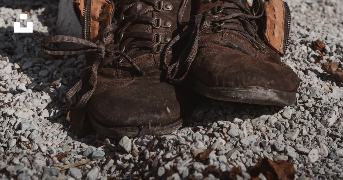 Shoes With Rocks Inside A pair of brown shoes sitting on top of a pile of rocks photo – Free ...