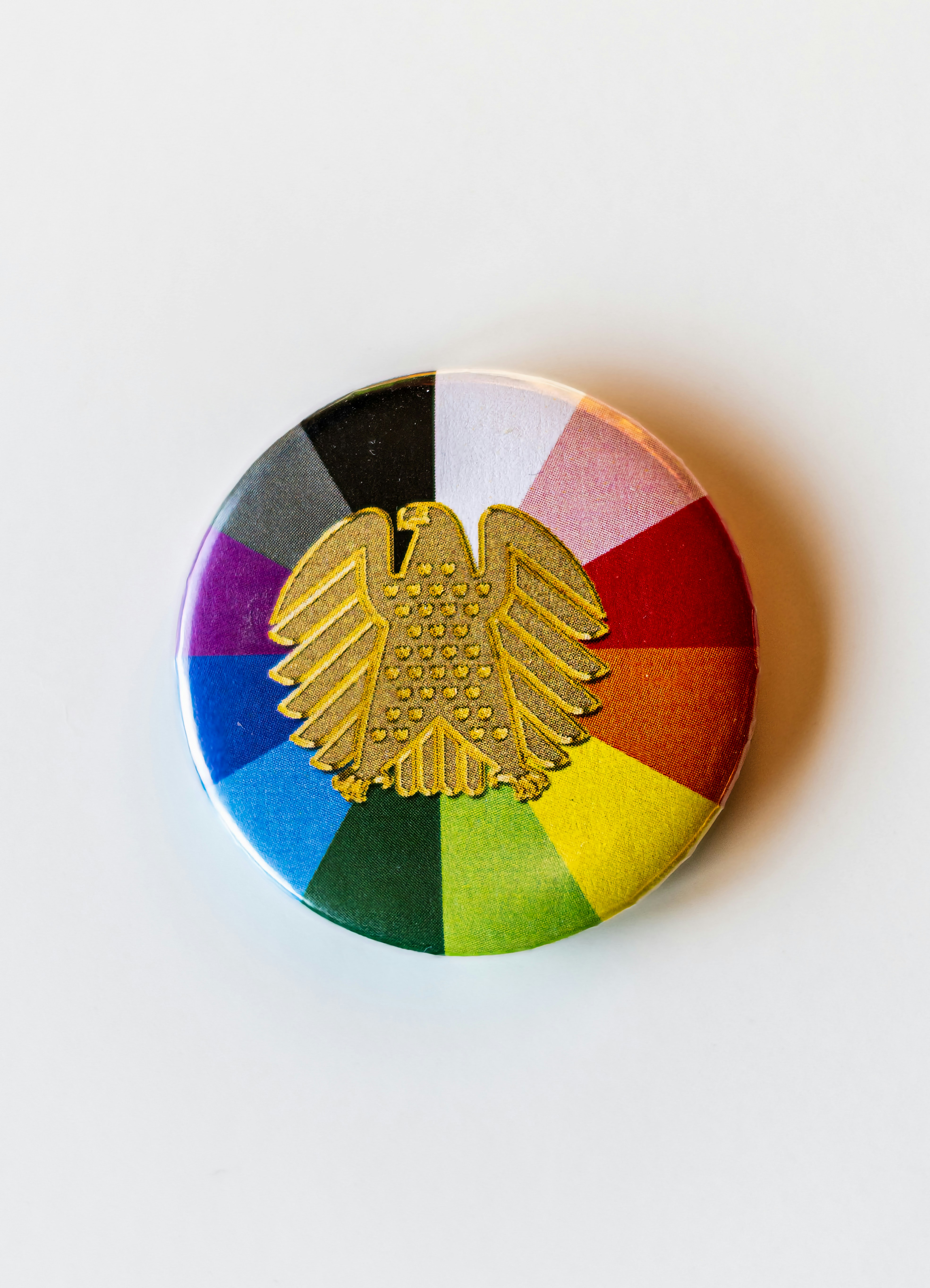 A colorful button with a gold eagle on it