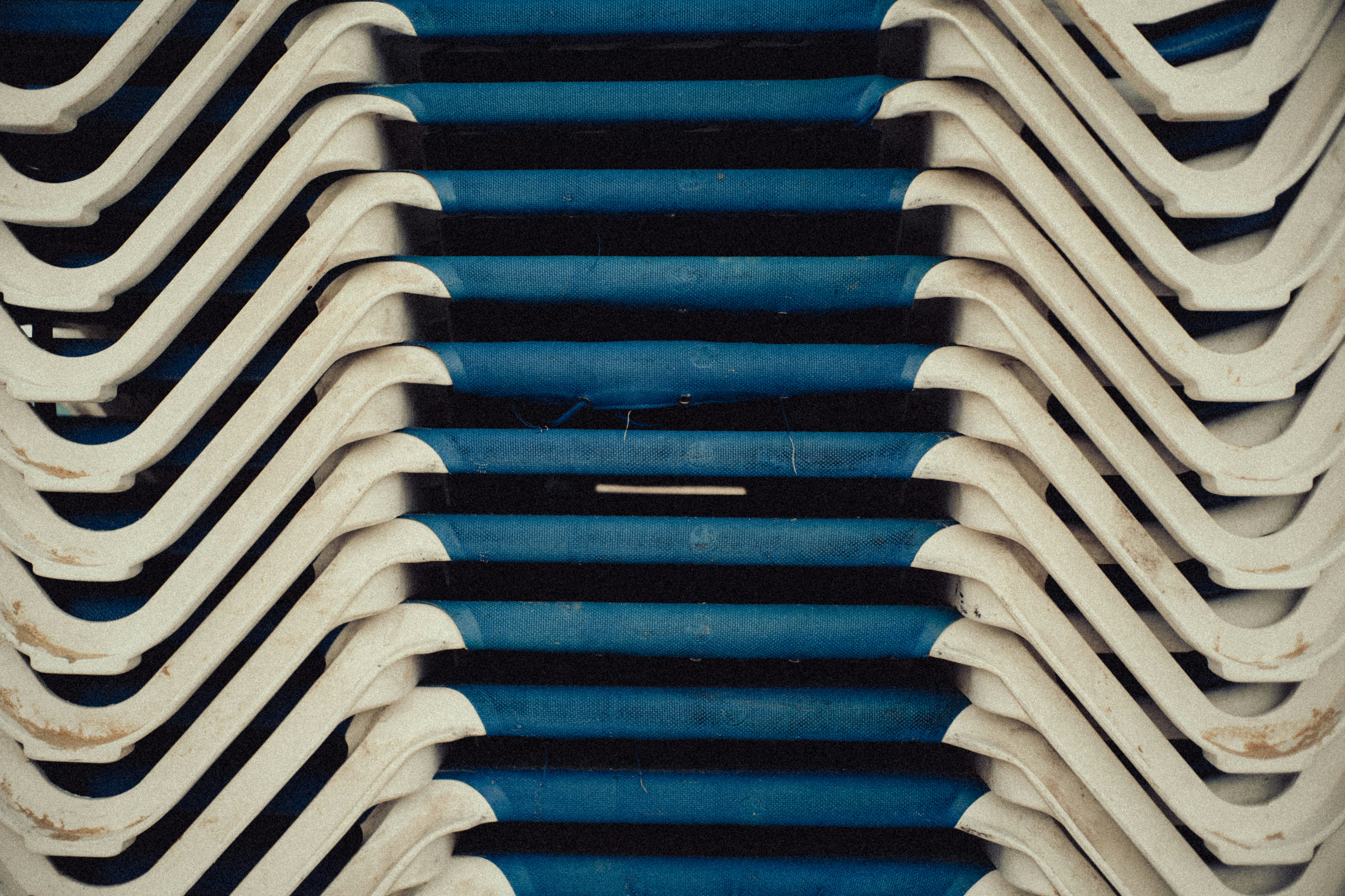 A bunch of blue and white chairs stacked on top of each other