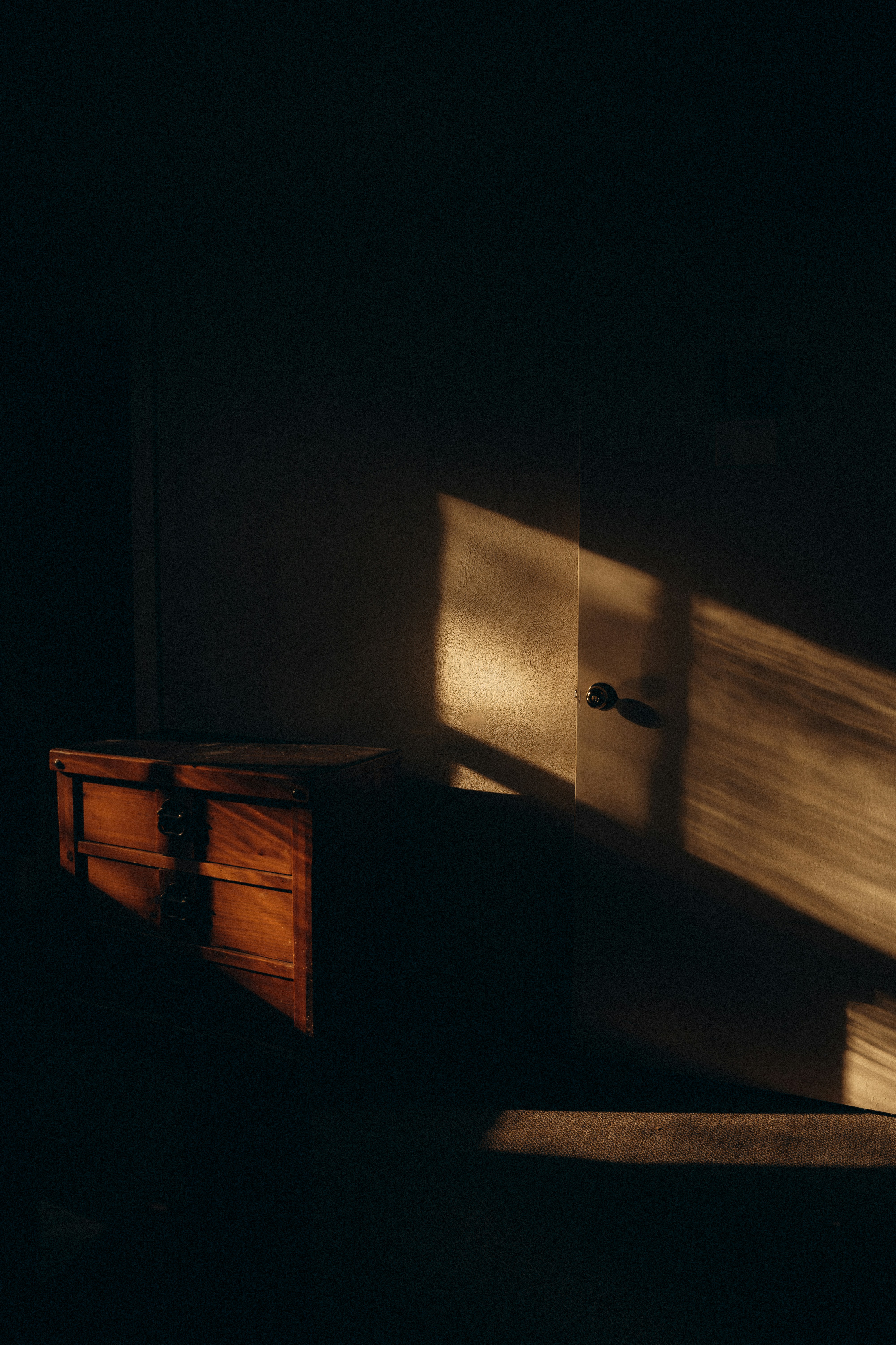 A dark room with a dresser and a window