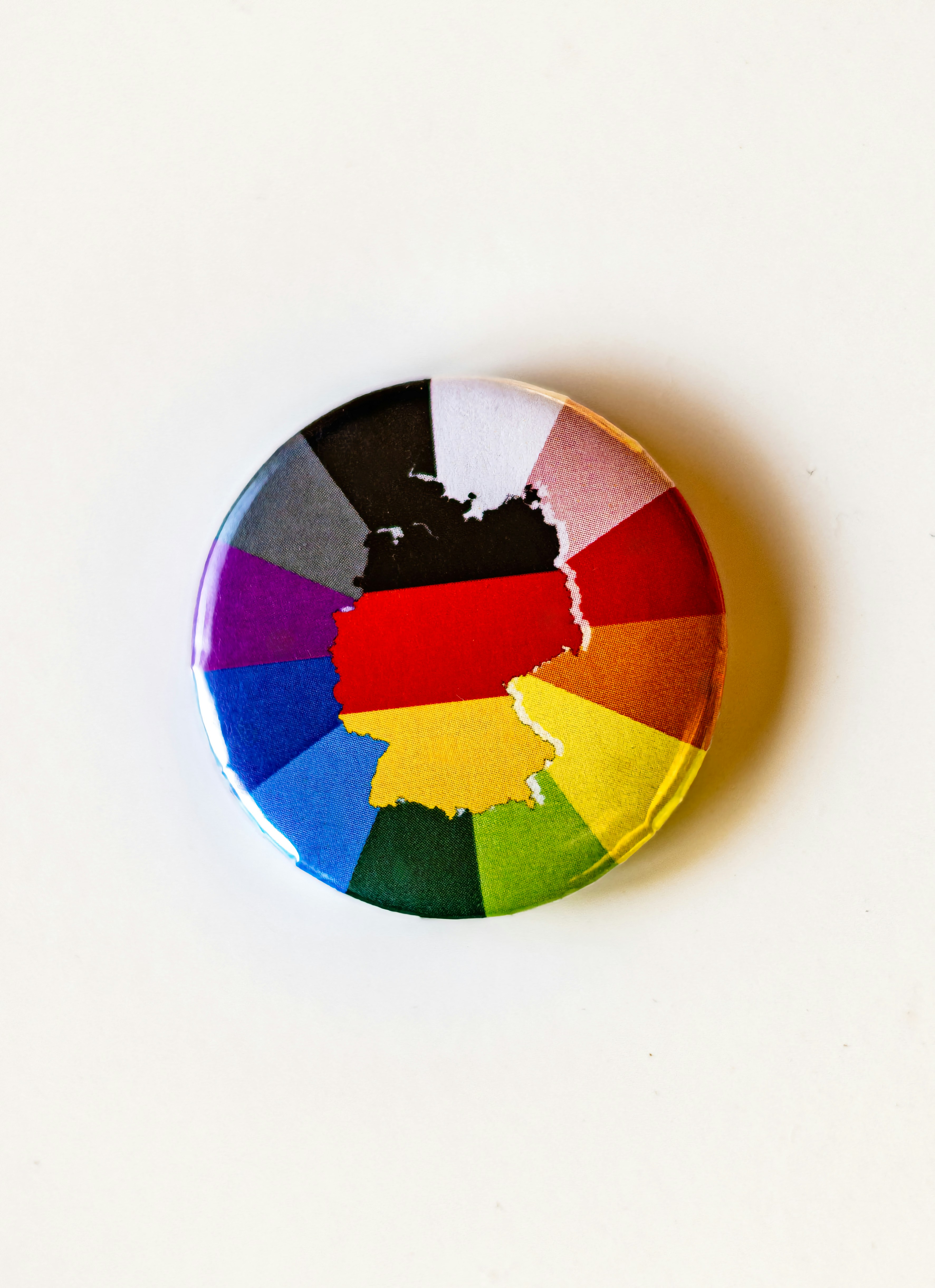 A multicolored button with a white background
