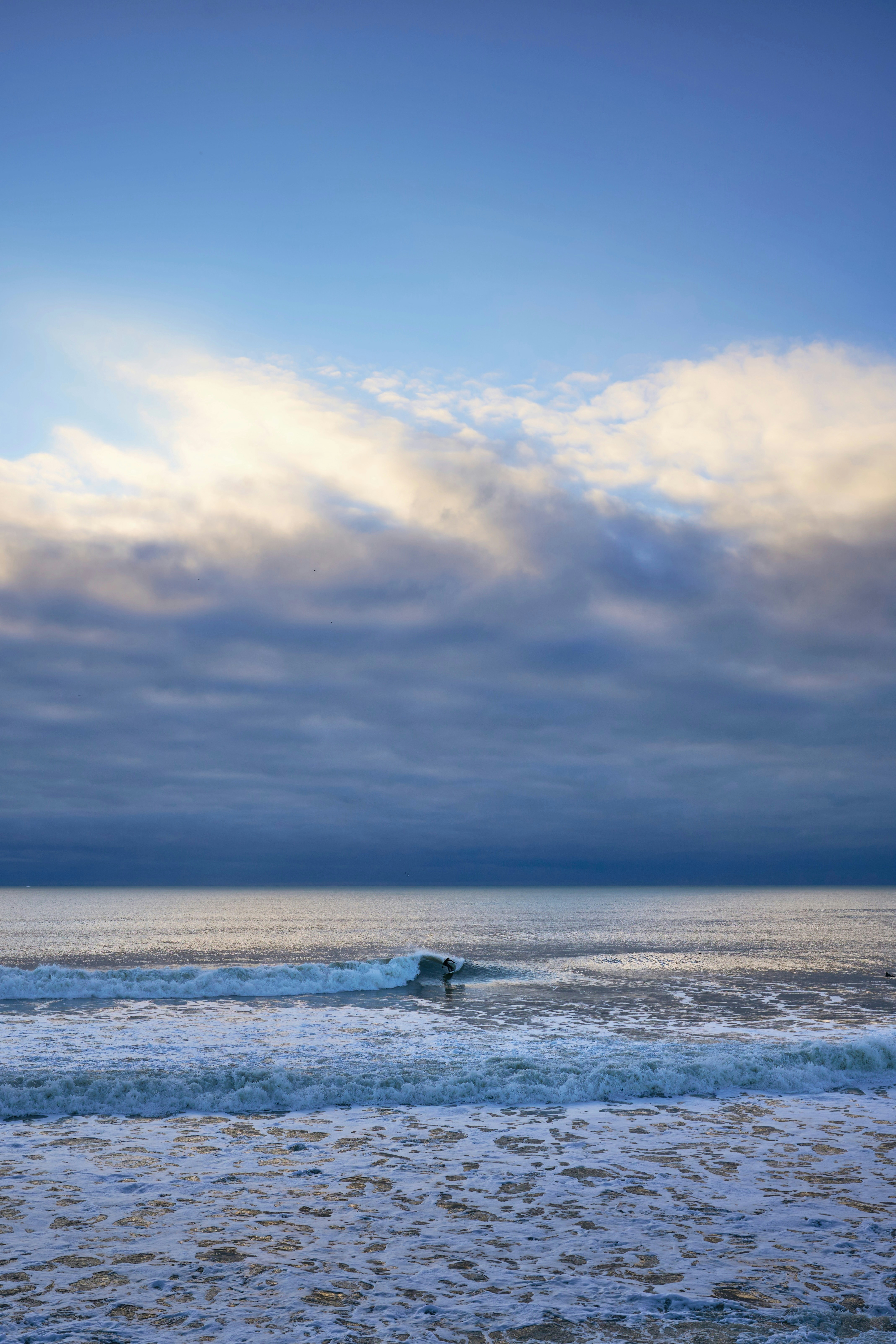 A person riding a surfboard on a wave in the ocean