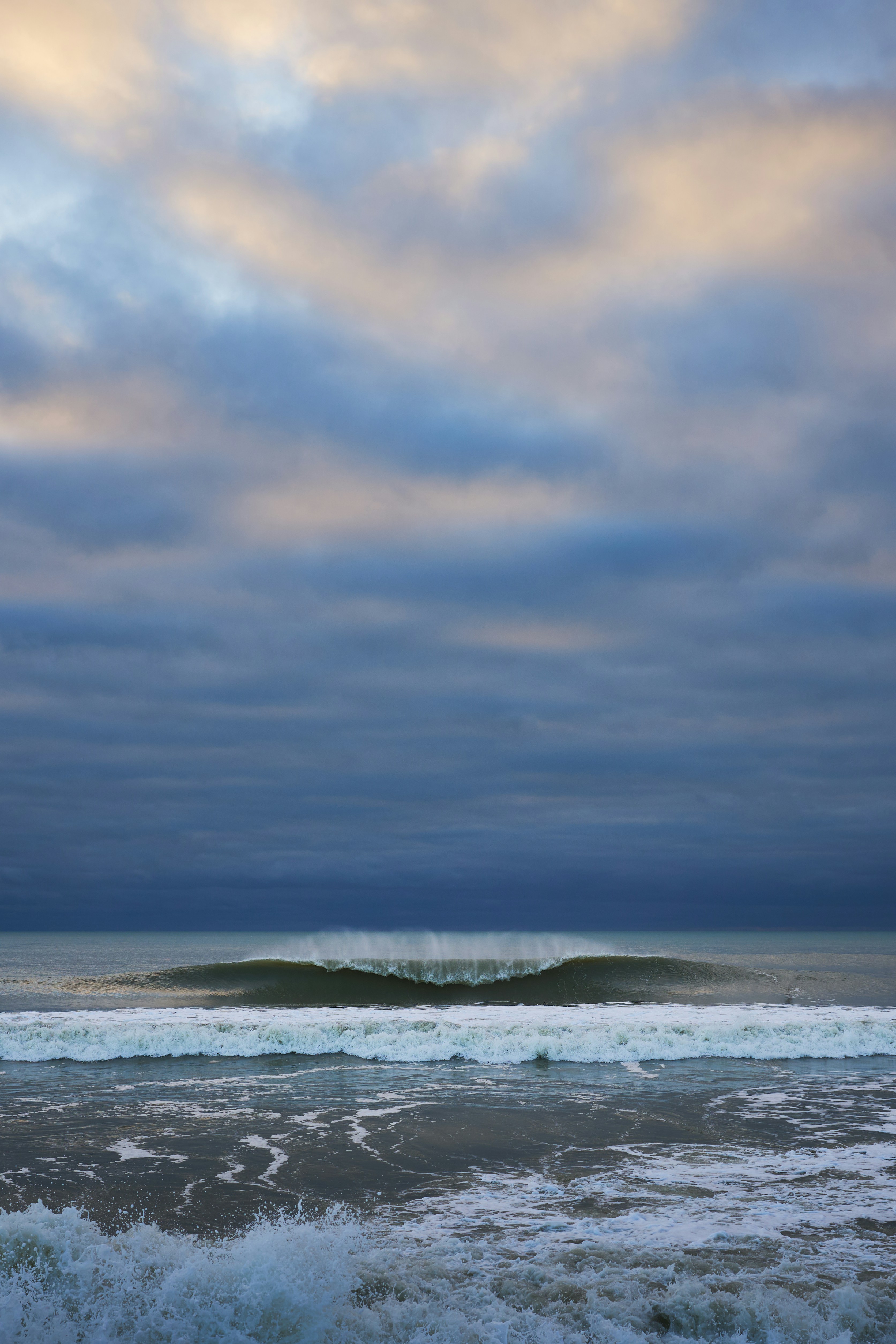 A person walking on the beach with a surfboard