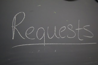 A chalkboard with the word request written on it