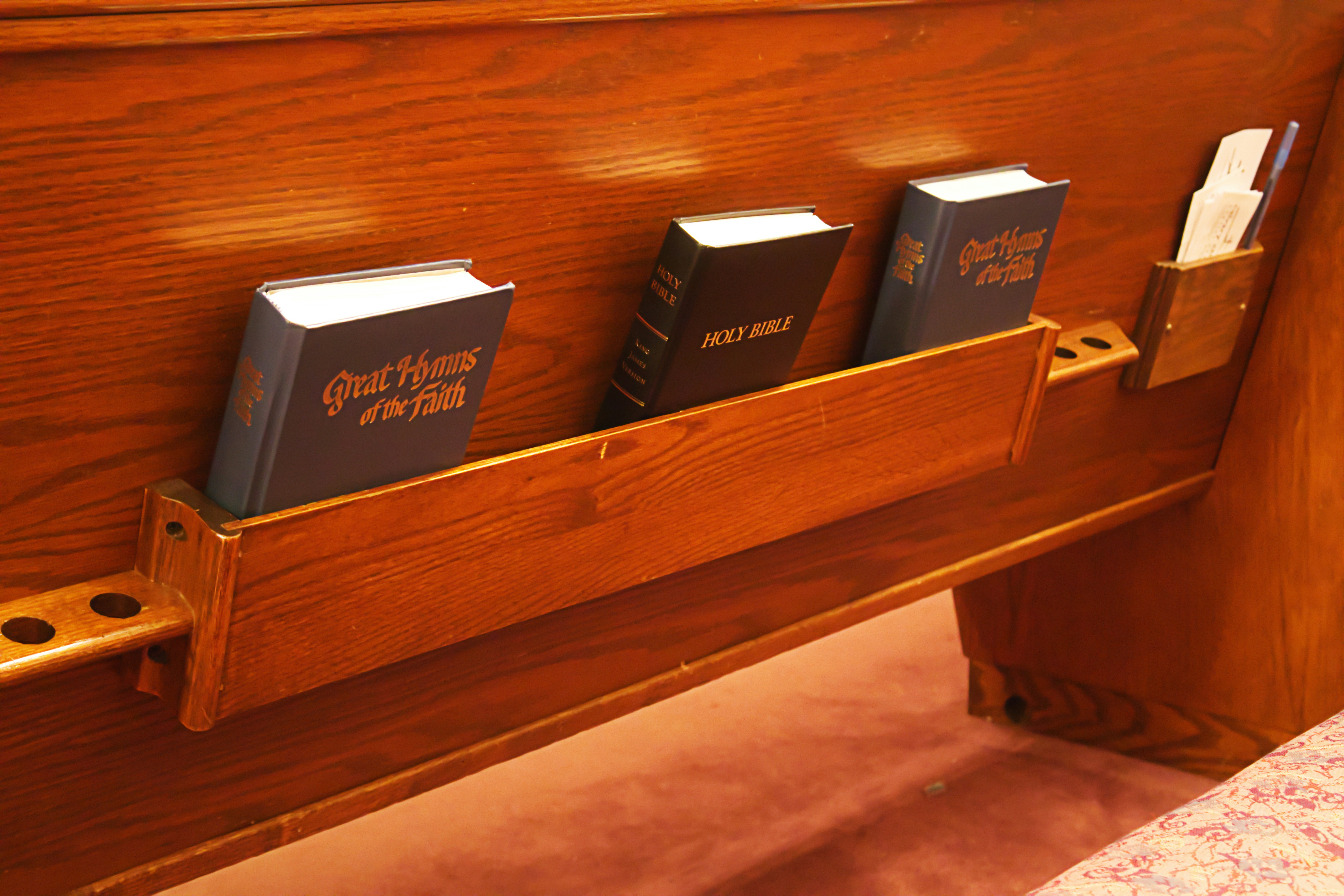 A wooden bench with three books on it