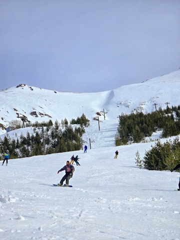 A group of people riding skis down a snow covered slope