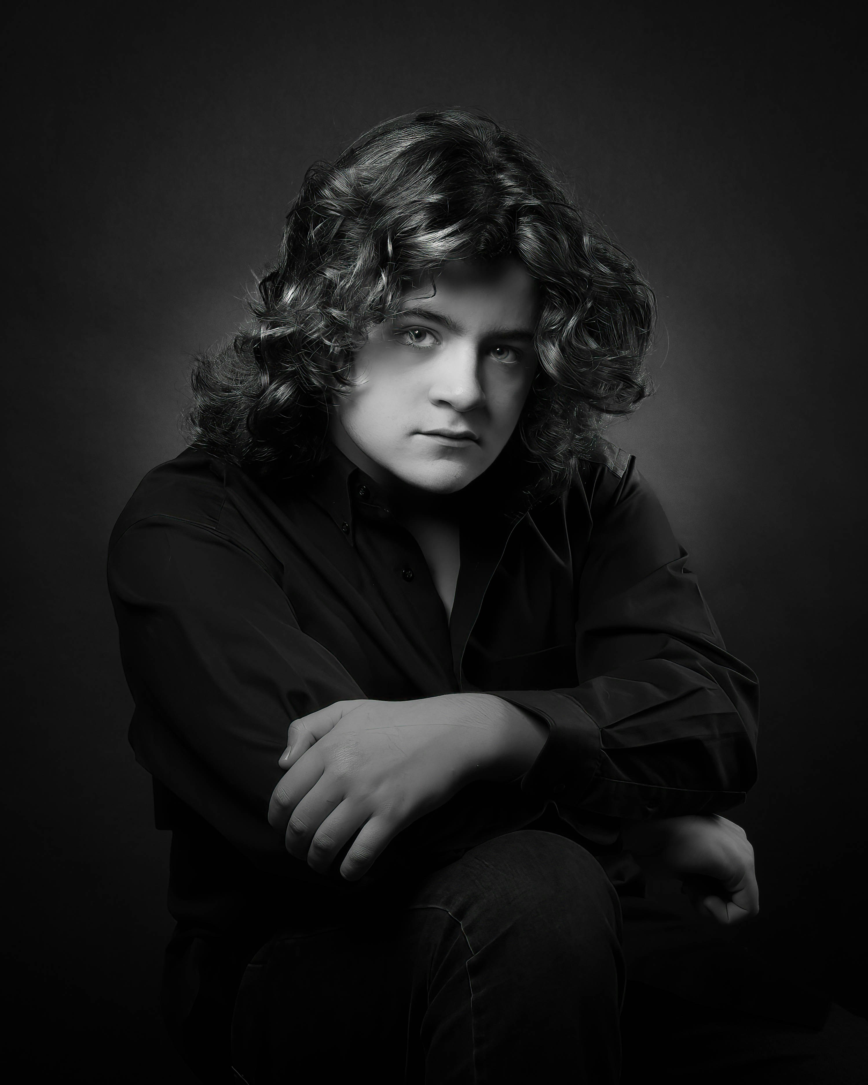 A black and white photo of a man with long hair