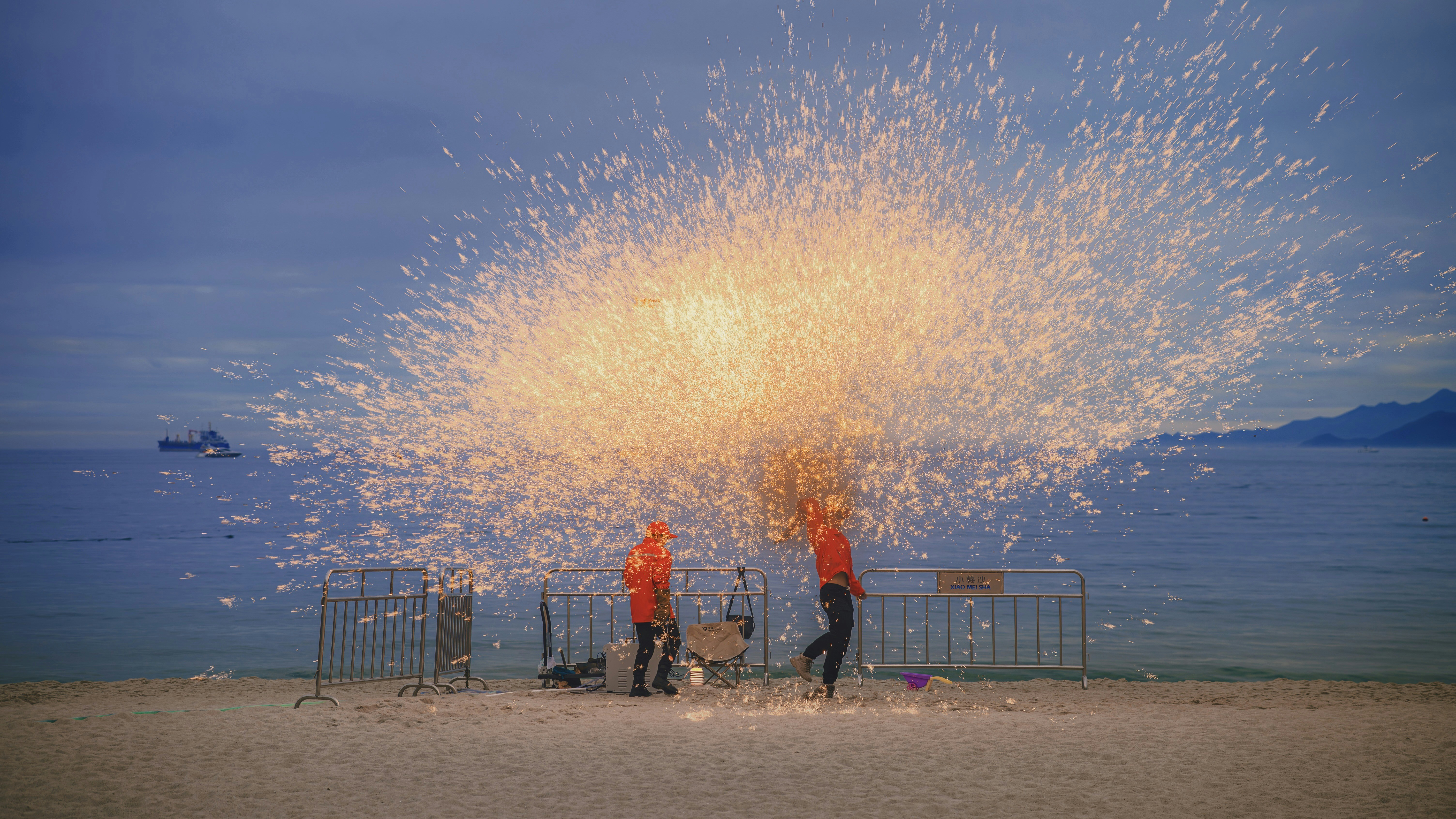 A group of people standing on top of a sandy beach