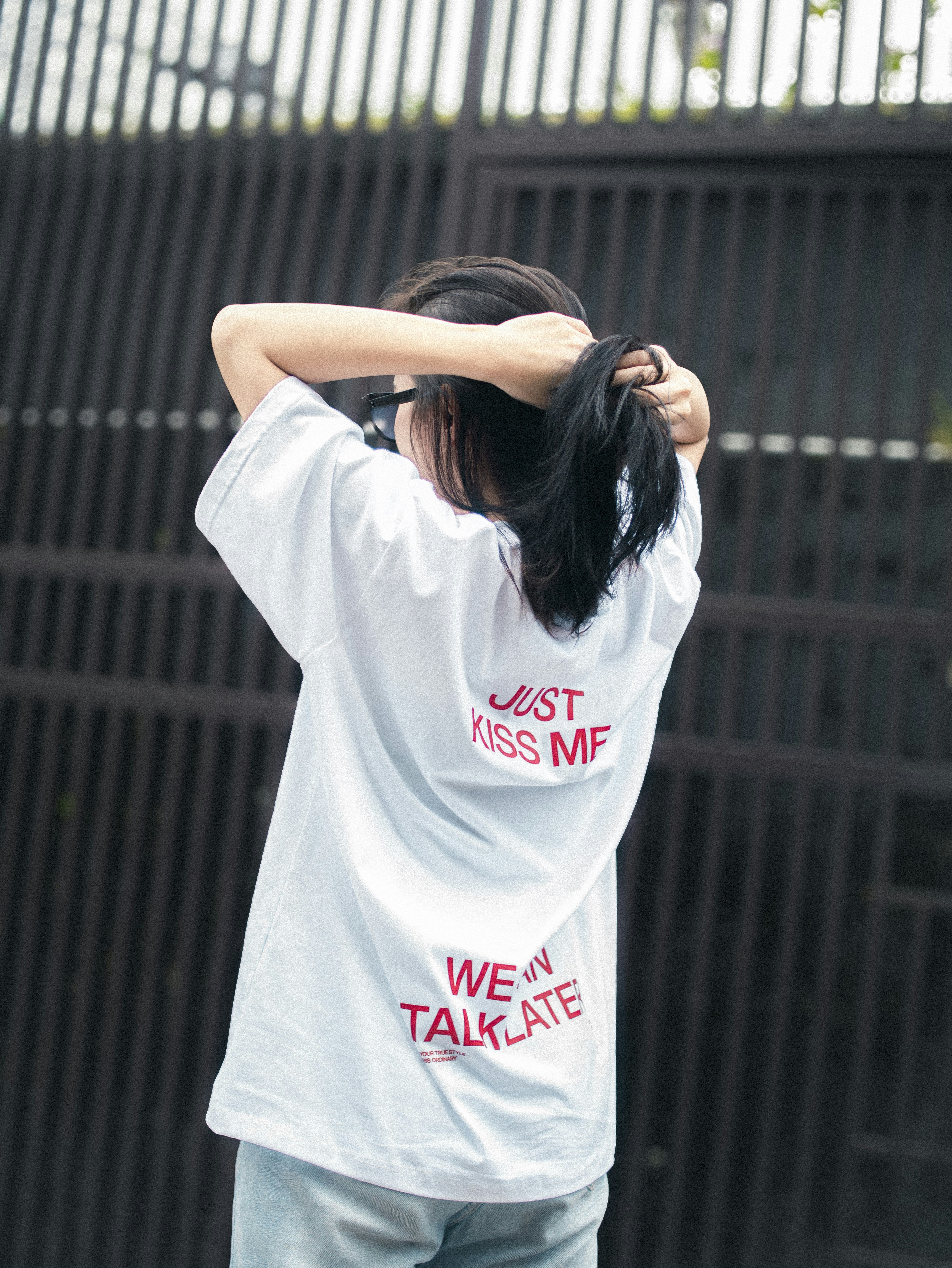 Seorang wanita berbaju putih memegangi rambutnya