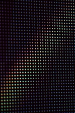 A close up view of a black background with multicolored dots
